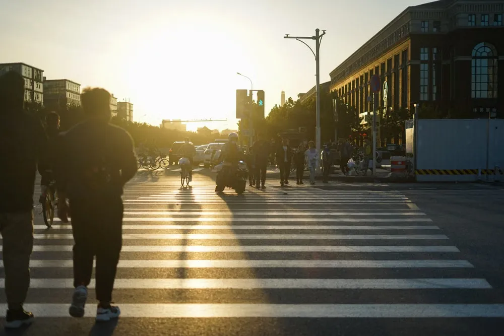 日暮れの街を横断する人々